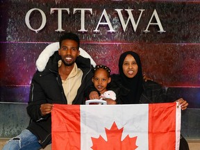 Nasro Adan Mohamed, a Somali refugee based in Brockville, has been trying since pre-pandemic to bring her husband and young daughter to Canada but they have been stuck in transit in Uganda. Nasro poses for a photo with her husband Liiban Ahmed Khadiye and daughter Afnaan Liiban Ahmed at the Ottawa airport Wednesday.