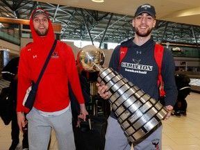 Carleton University basketball players Grant Shephard and Gebrael Samaha, along with their teammates, arrive at the Ottawa airport Monday afternoon after winning the national championship in Halifax on Sunday.