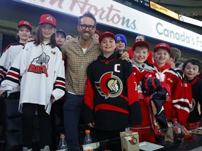 Actor Ryan Reynolds attending the Ottawa Senators game at the Canadian Tire Centre in Ottawa Thursday night.  Ryan climbed over the wall of the box next to his to greet some young Senatror fans.