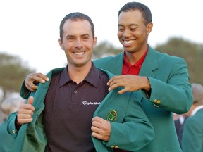 Masters champion Tiger Woods, right, helps Canadian Mike Weir don the traditional green jacket after the Bright's Grove, Ont. native won the 2003 Masters.