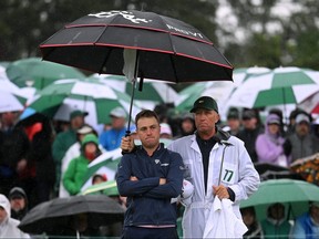 Justin Thomas of the United States and his caddie Jim 'Bones' Mackay react to his bogey on the 18th green during the continuation of the weather delayed second round of the 2023 Masters.