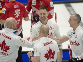 Ryan Harnden (left) and brother E.J. Harnden take part in the team celebration after Canada defeated the Czech Republic 8-3 on April 4, 2023 at the world men's curling championship in Ottawa.
