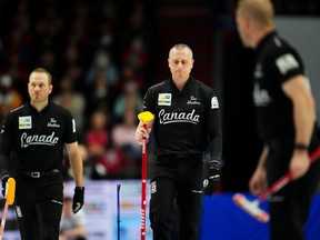 Canadian second E.J. Harnden, middle, makes his way down the ice in the third end during the gold medal game against Scotland at the men's world curling championship in Ottawa on Sunday, April 9, 2023.