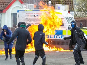 Masked youths attack a police landrover with petrol bombs after Republicans took part in a march to commemorate the 1916 Easter Rising, in the Creggan area of Derry in Northern Ireland on April 10, 2023.
