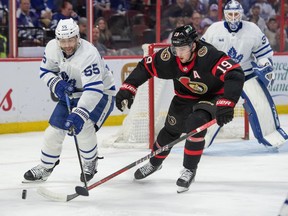 Maple Leafs defenceman Mark Giordano (55) and Senators' Drake Batherson (19) battle for the puck