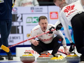 Canadian skip Brad Gushue shouts to second E.J.Harnden, right, and lead Geoff Walker as they brush a stone from third Mark Nichols into the house in the fourth end of Friday evening's game against Sweden.