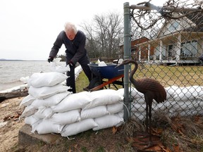 Dave Fitzsimons building a retaining wall along the waterfront of his home in Constance Bay Friday. Residence of the area are hoping that the water does not rise any higher this weekend.