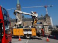 Ottawa crews reinstall traffic lights on Wellington Street in front of Parliament Hill in Ottawa Thursday.