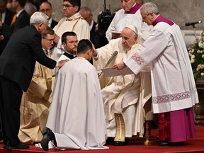 Pope Francis applies the Chrism oil on the forehead of a freshly baptised man, giving him the Sacrament of Confirmation, during the Easter Vigil mass on April 8, 2023 at St. Peter's basilica in The Vatican, as part of celebrations of the Holy Week.