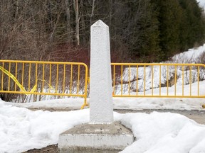 A Canada/US border marker is shown on Roxham road in Hemmingford, Que., Saturday, March 25, 2023.