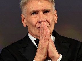 Harrison Ford reacts on stage before being awarded with an Honourary Palme d'or prior to the screening of the film "Indiana Jones and the Dial of Destiny" during the 76th edition of the Cannes Film Festival in Cannes, southern France, on May 18, 2023.