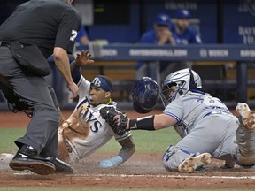 Home plate umpire Jordan Baker watches as Blue Jays catcher Alejandro Kirk, right, tags out Rays' Wander Franco, who was trying to score from third base on a throw from Toronto center fielder Kevin Kiermaier during the fifth inning on Monday, May 22, 2023, in St. Petersburg, Fla.