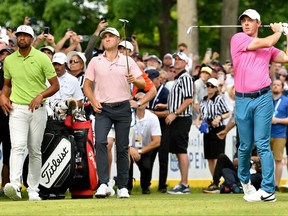 Rory McIlroy of plays his shot from the 16th tee as Tony Finau of the and Justin Thomas look on during the final round of the RBC Canadian Open last summer.