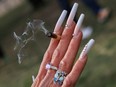 A woman shows off her nails while holding a joint in Denver, Colorado, April 20, 2023.