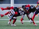Alouettes wide receiver Kevin Kaya (88) is tackled by Redblacks defensive backs Brandin Dandridge (37) and Abdul Kanneh (14) on a play in the first half of Friday's game.