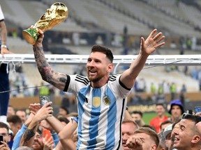 Lionel Messi of Argentina celebrates with teammates and the FIFA World Cup.
