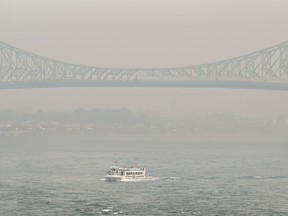 A boat passes by the Jacques Cartier bridge obscured by a haze of smog in Montreal, Sunday, June 25, 2023, as a smog warning is in effect for the city and multiple regions of the province due to forest fires. Smoky, dangerous air is settling over parts of western Quebec and eastern Ontario this morning and the number of forest fires burning across Canada is creeping higher once again.