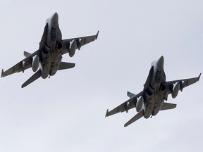 A file photo shows CF-18 jets flying over McMahon Stadium in Calgary before another CFL game there in September 2022.