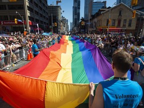 Volunteers with Pride Toronto carry a large rainbow flag during the 2019 Pride Parade in Toronto, Sunday, June 23, 2019. The city hosts its annual Pride parade today, with tens of thousands expected to join Canada's largest LGBTQ celebration.