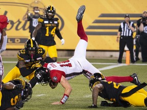 Ottawa Redblacks quarterback Dustin Crum is tackled short of the end zone by Hamilton Tiger-Cats defenders.