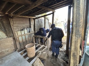South African police officers dismantle a shack used by illegal gold miners in the Angelo Informal Settlement, in Boksburg, South Africa, Thursday July 6, 2023.