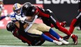 Winnipeg Blue Bombers wide receiver Drew Wolitarsky is tackled by Ottawa Redblacks defensive back Damon Webb (left) and defensive back Brandin Dandridge Saturday in Ottawa. Justing Tang/The Canadian Press