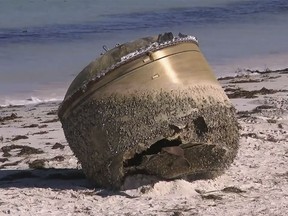 In this image made from video, a cylindrical object is seen on beach in Green Head, Australia, July 17, 2023. Authorities were investigating on Tuesday whether a cylindrical object about the size of a small car that washed up on a remote Australian beach is space junk from a foreign rocket. (CHANNEL 9 via AP)