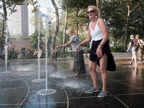 People keep cool in a fountain in Battery Park in Manhattan