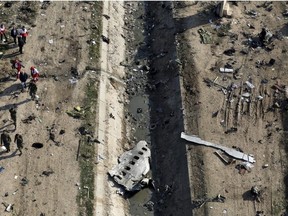 Rescue workers search the scene where a Ukrainian plane crashed in Shahedshahr, southwest of the capital Tehran, Iran, on January 8, 2020. The head of Iran's civil aviation organization says his government will launch compensation talks in October with Canada and other countries that lost citizens when the Iranian military shot down a civilian jetliner earlier this year. Touraj Dehqani Zangeneh made the comments to Iran's official news agency over the weekend amid new Iranian claims about what happened on Jan. 8, when Ukraine International Airlines Flight PS752 was downed shortly after takeoff from Tehran.
