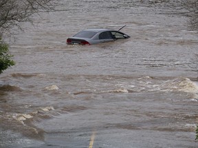 An abandoned car in a mall parking lot is seen in floodwater following a major rain event in Halifax