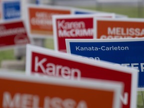Campaign signs for provincial byelections in the riding of Kanata-Carleton are seen, Thursday, July 20, 2023 in Ottawa. Summer is the time for barbecues, bare feet and beaches, and, for residents of two Ottawa and Toronto-area ridings, byelections.