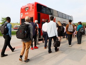 People catch a bus at Hurdman Station in Ottawa on Tuesday.