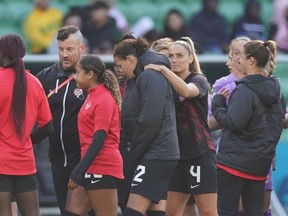 Canada's Christine Sinclair (12) is consoled by Shelina Zadorsky (4) as the players leave the field following a 0-0 draw against Nigeria in Group B soccer action at the FIFA Women's World Cup in Melbourne, Australia, Friday, July 21, 2023.
