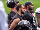Justin Howell (centre) looks on during a Redblacks practice.