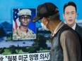 In this photo taken in Seoul on August 16, 2023, a man walks past a television showing a news broadcast featuring a photo of US soldier Travis King (C), who ran across the border into North Korea while part of a tour group visiting the Demilitarized Zone on South Korea's border on July 18. Travis King defected to North Korea to escape "mistreatment and racial discrimination in the US Army", state media said Wednesday, Pyongyang's first official confirmation they were holding the American soldier.