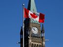The Canadian flag flies in front of the Peace Tower on Parliament Hill in Ottawa.