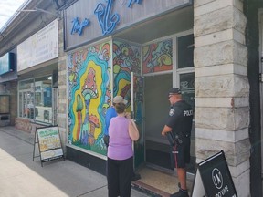 A police officer stands outside Magic Mush Dispensary Ottawa on Bank Street on Thursday.