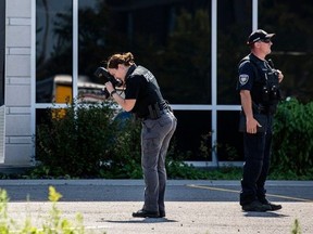 An Ottawa police officer snaps photos of bullet
