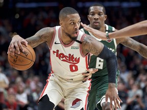 Portland Trail Blazers guard Damian Lillard dribbles around Milwaukee Bucks guard Eric Bledsoe during a game last season.