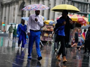 People walk under umbrellas during a coastal storm in Lower Manhattan on September 29, 2023 in New York City.