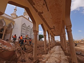 Rescue teams assist in relief work in Libya's eastern city of Derna on September 18, 2023 following deadly flash floods. A week after a tsunami-sized flash flood devastated the Libyan coastal city of Derna, sweeping thousands to their deaths, the international aid effort to help the grieving survivors slowly gathered pace.