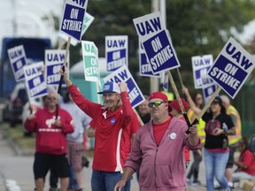 FILE - United Auto Workers members walk a picket line during a strike at the Ford Motor Company Michigan Assembly Plant in Wayne, Mich., Friday, Sept. 15, 2023.