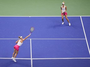 Gabriela Dabrowski, of Canada, left, returns a shot alongside doubles partner Erin Routliffe, of New Zealand, during the women's doubles final of the U.S. Open tennis championships against Laura Siegemund, of Germany, and Vera Zvonareva, of Russia, Sunday, Sept. 10, 2023, in New York.