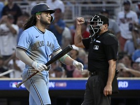 Bo Bichette, left, of the Toronto Blue Jays reacts after striking out against the Minnesota Twins during the eighth inning in Game 1 of their AL Wild Card Series against the Minnesota Twins at Target Field on Tuesday, Oct. 3, 2023, in Minneapolis, Minn.