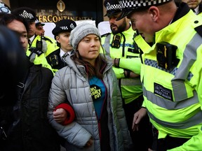 A police officer speaks to Swedish climate activist Greta Thunberg moments before being arrested outside the InterContinental London Park Lane during the "Oily Money Out" demonstration organized by Fossil Free London and Greenpeace on the sidelines of the opening day of the Energy Intelligence Forum 2023 in London on Oct. 17, 2023.