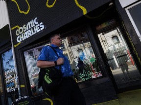 A man walks past Cosmic Charlies cannabis store in Toronto, Tuesday, Oct. 3, 2023.