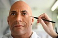 A painter works on updating a wax figure of Dwayne Johnson at the Grévin Museum in Paris