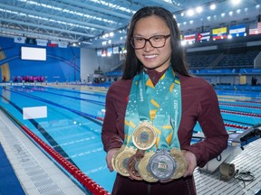 Canada's Maggie Mac Neil shows off her medal haul at the conclusion of the swimming competition at the Pan American Games in Santiago, Chile on Wednesday, Oct. 25, 2023.