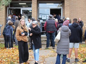 People wait outside the Centre pour l'enfant et la famille ON y va in Cornwall while being reunited with students who had been in lockdown there after evacuating Ecole Secondaire La Citadelle on Nov. 1.