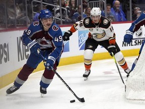 Colorado Avalanche defenseman Samuel Girard, left, collects the puck as Anaheim Ducks center Ryan Strome pursues in the second period of an NHL hockey game Wednesday, Nov. 15, 2023, in Denver.